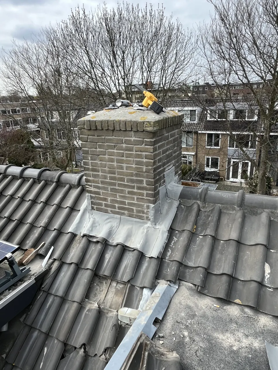 Schoorsteen met vernieuwde afwerking op een pannendak
